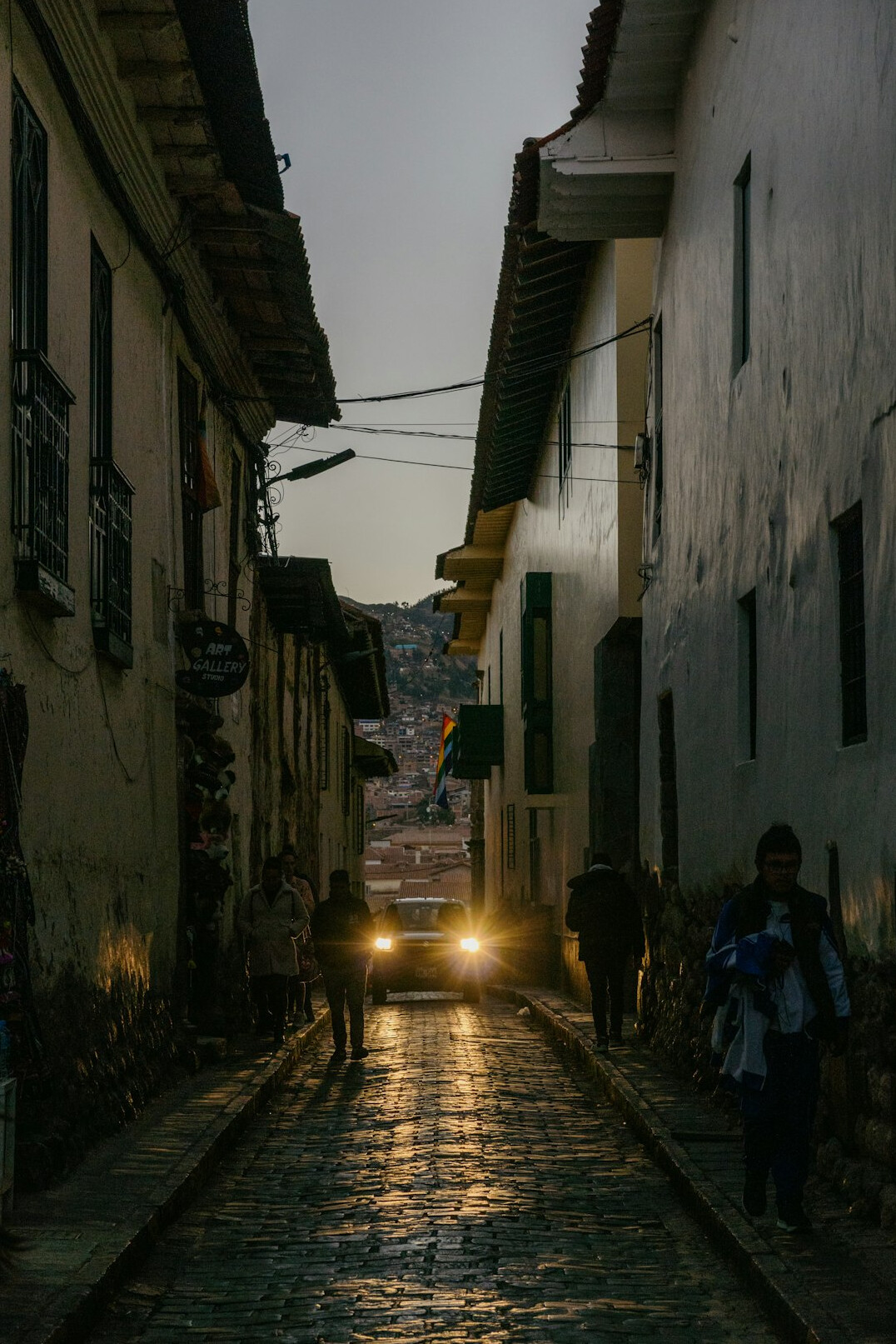 Rainy cobblestone street at night in an old South American city